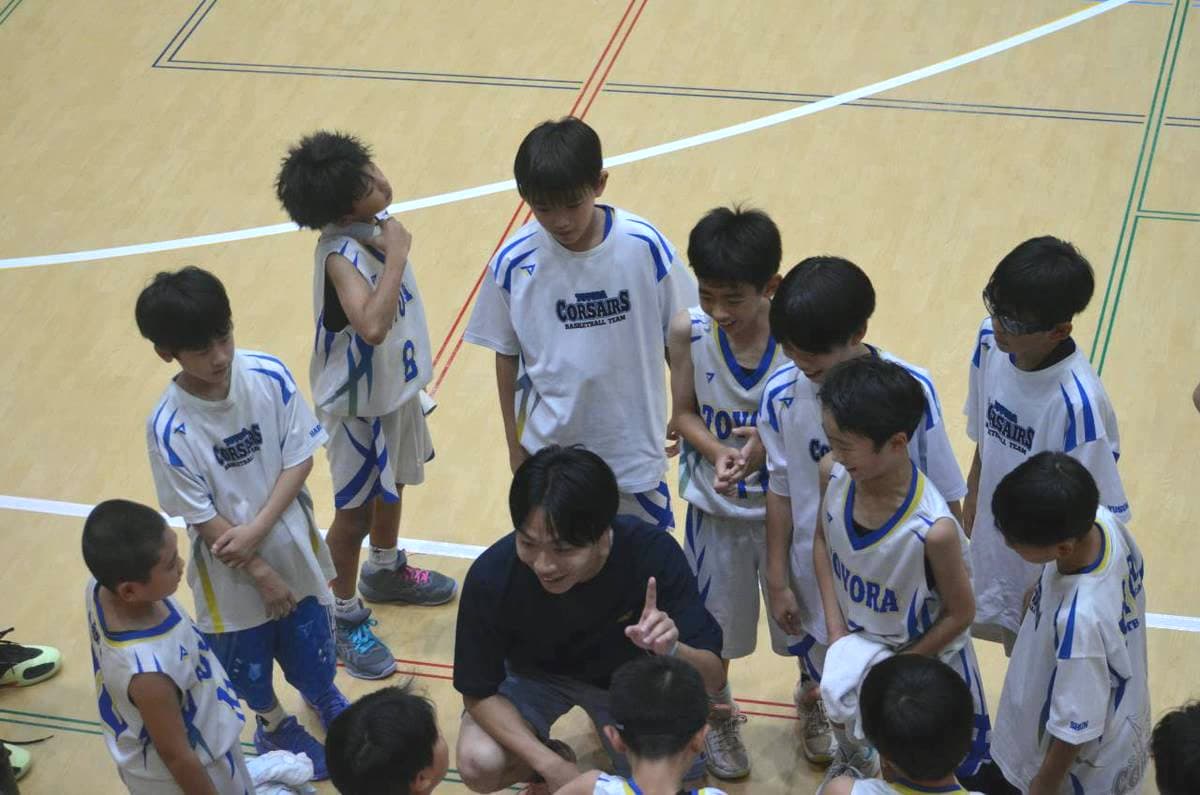 豊浦ミニバスケットボールの選手がコーチの話を聞く様子